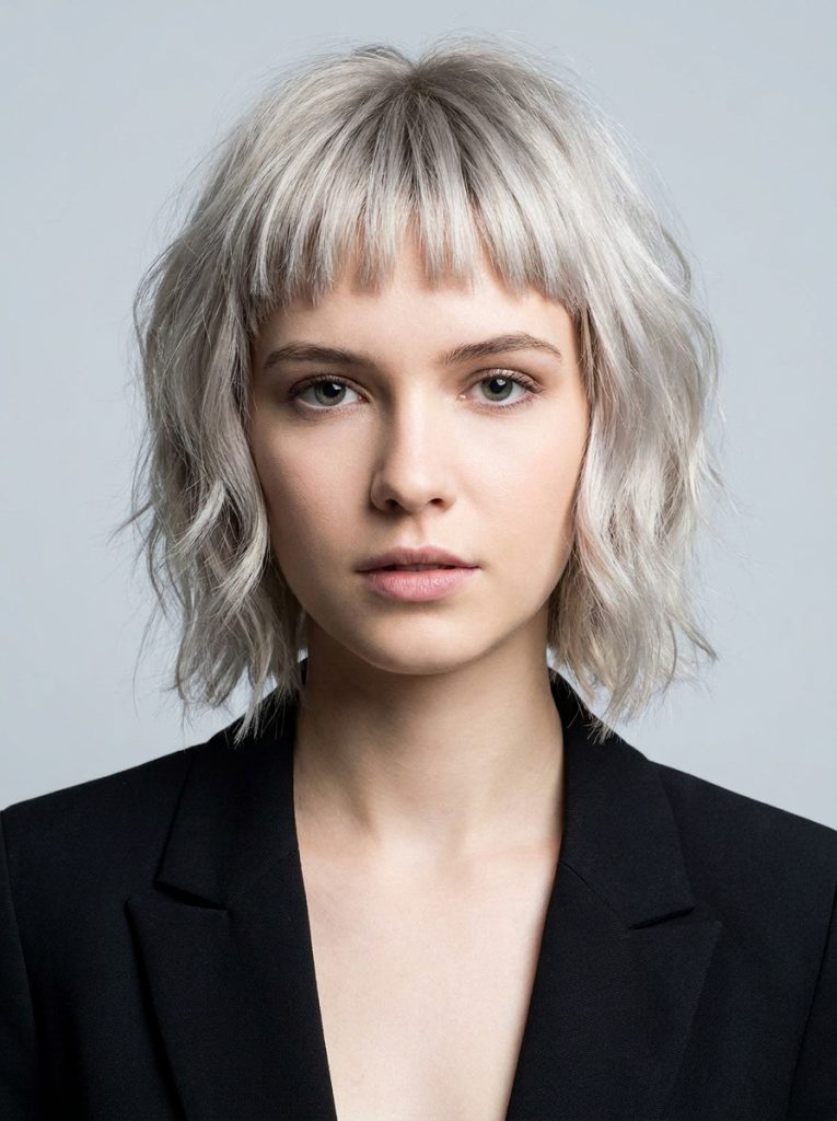 Short Ash Blonde Wavy Wolf Cut With Choppy Bangs